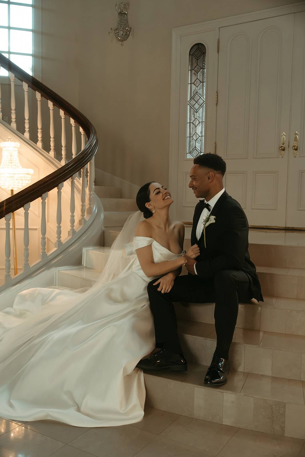 Bride and groom posing on steps inside the Chateau de Michellia