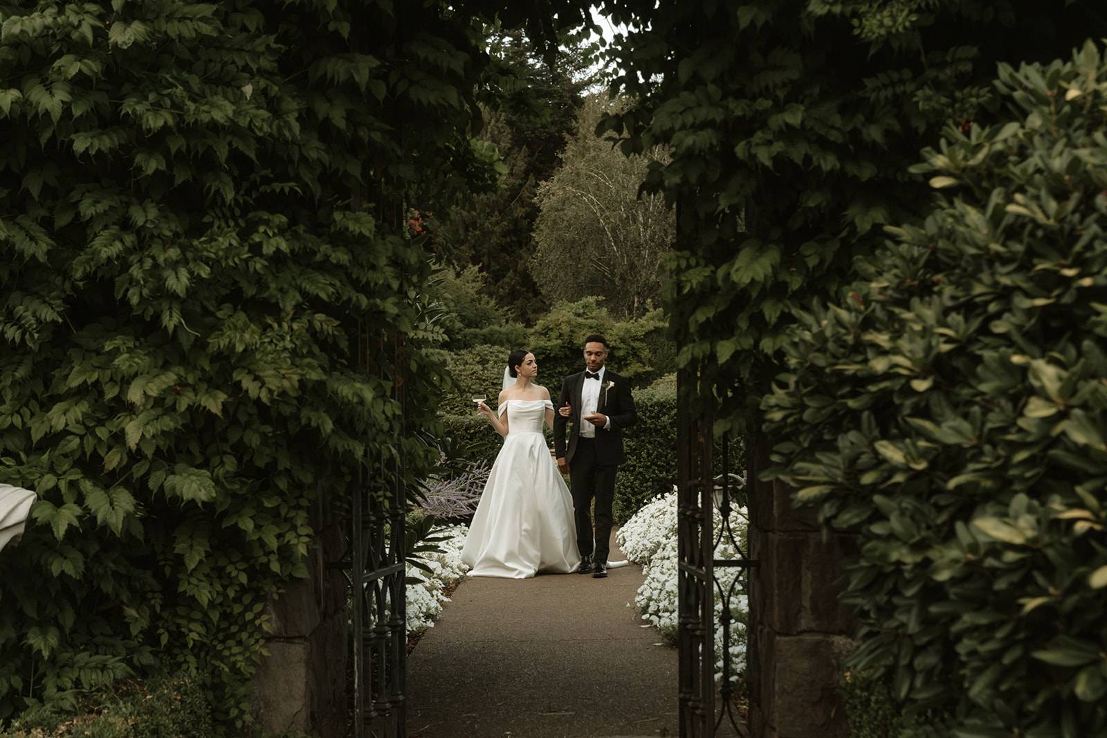 Lush green garden with classic bride and groom posing in the center