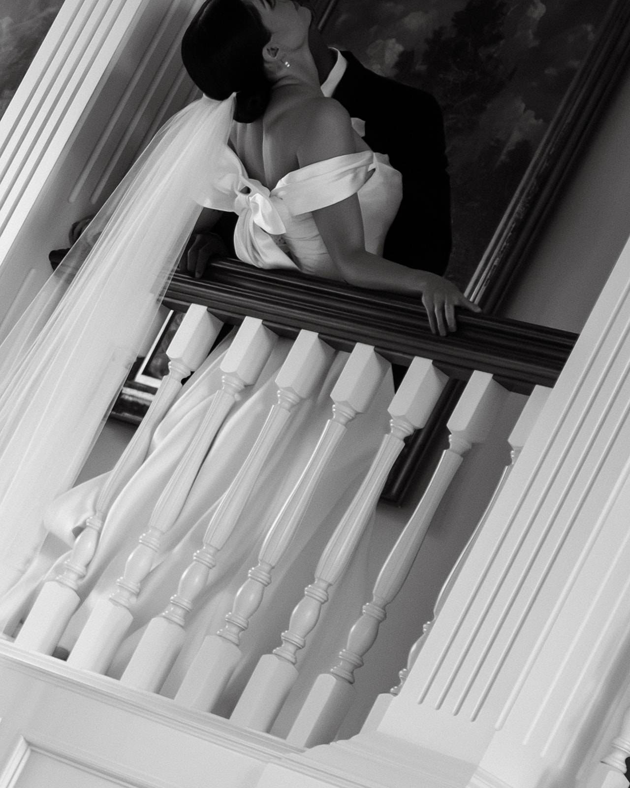 Bride and groom stealing a sultry moment on the balcony