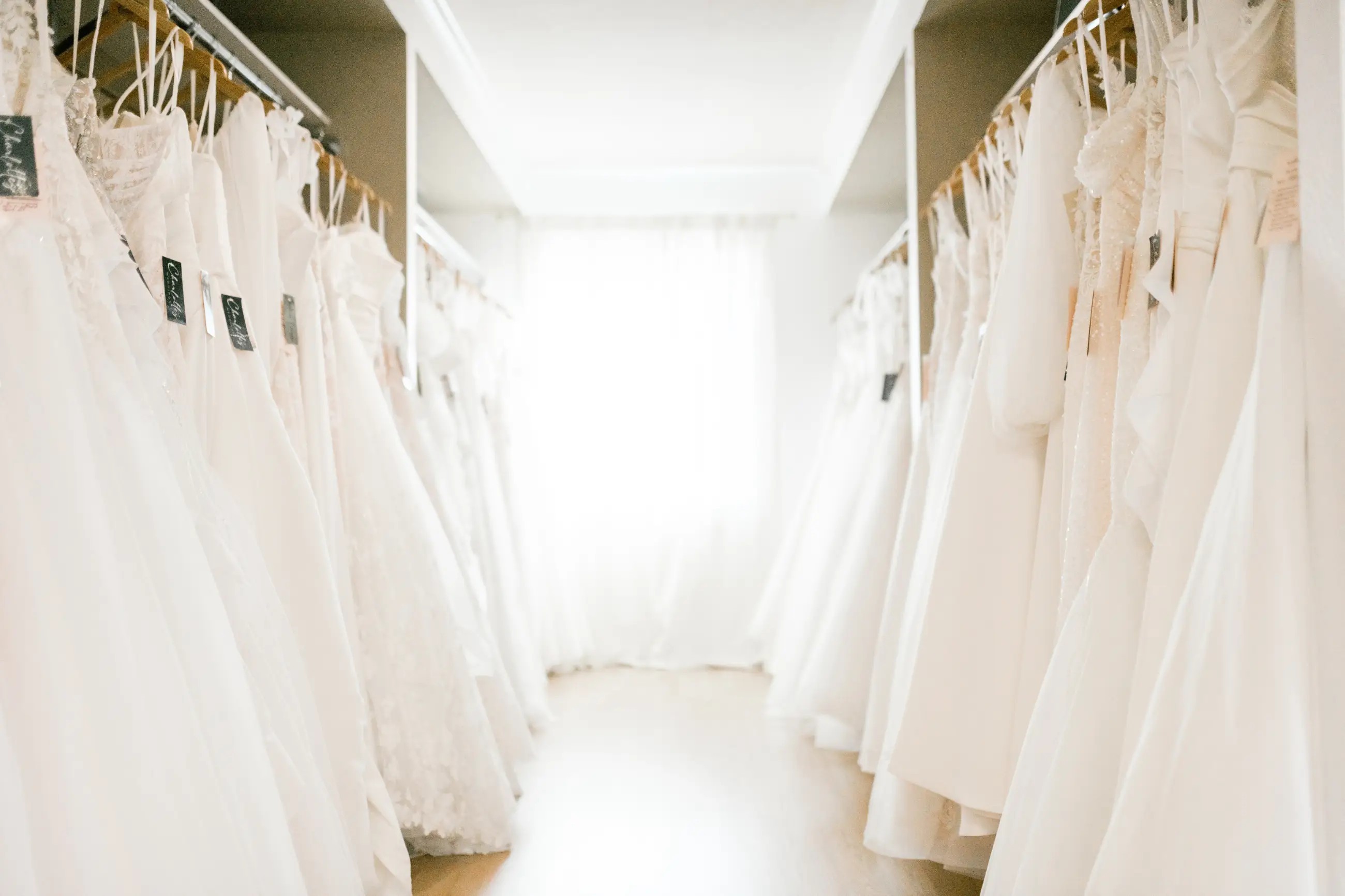 Racks of wedding dresses on showroom floor